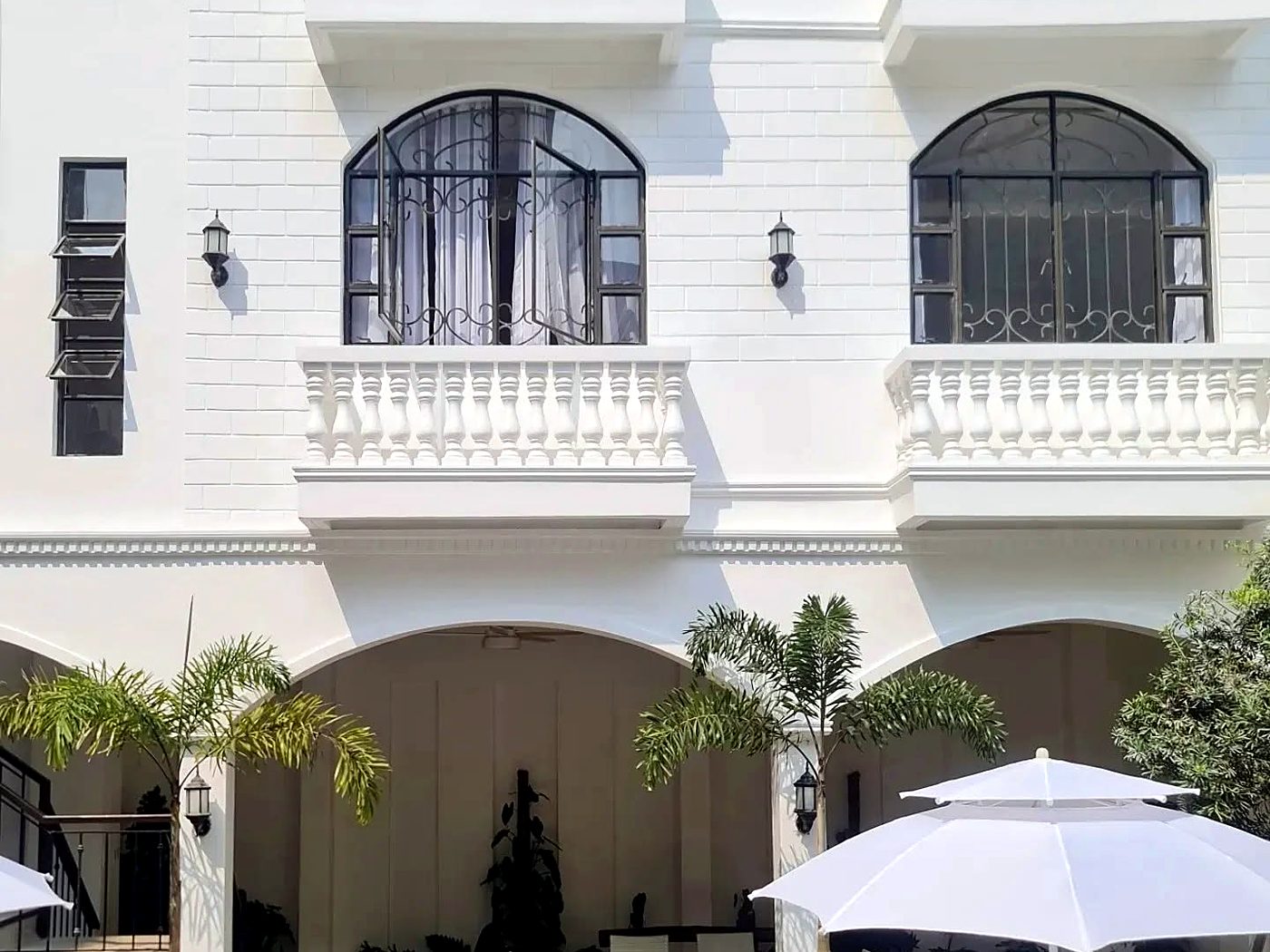 White facade with arched windows and balustrade balconies