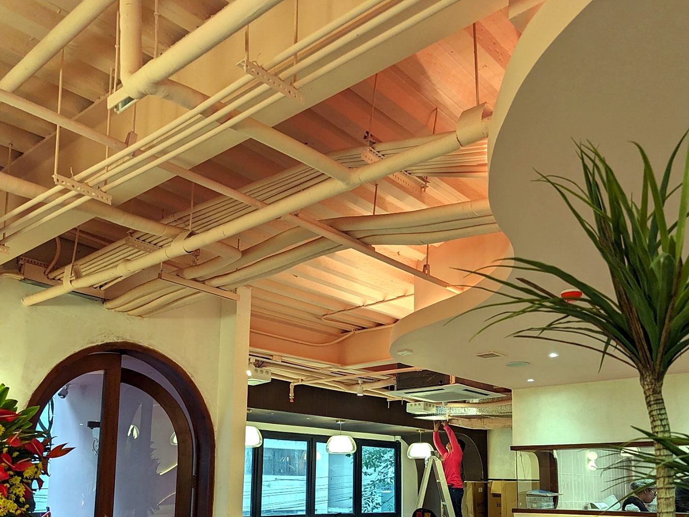 Café entrance with arched wooden door and sculpted ceiling